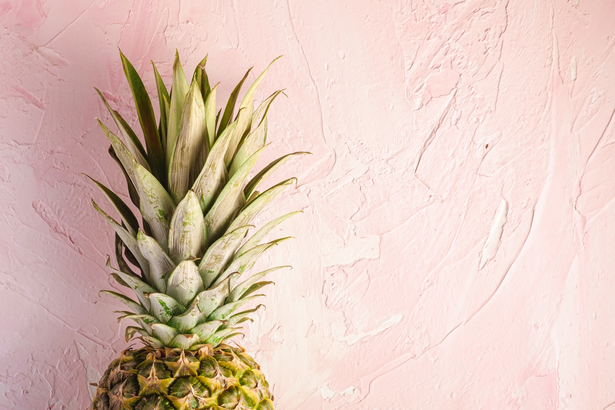 Fresh sweet pineapple on pink textured background